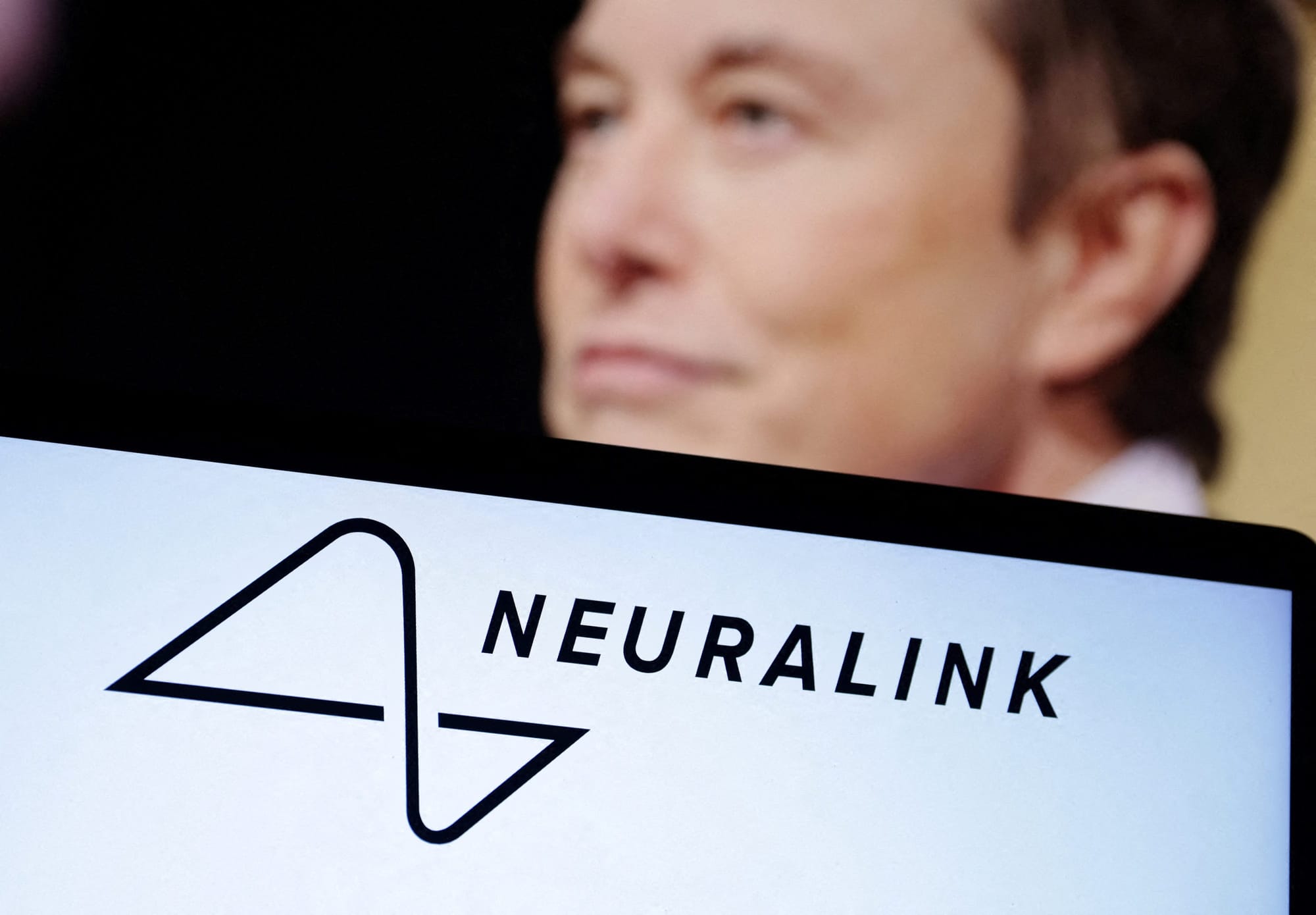 Illustration shows Neuralink logo and Elon Musk photo Illustration shows Neuralink logo and Elon Musk photo