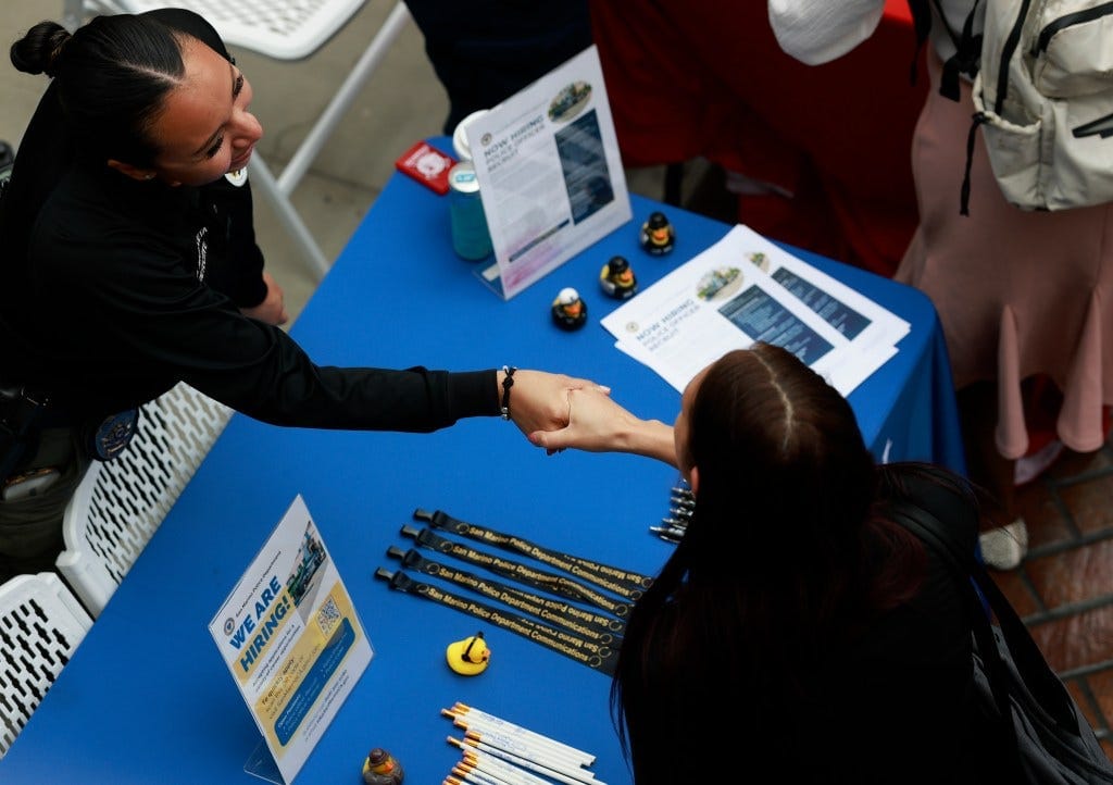 A recruiter and a job seeker shaking hands at a job fair in Los Angeles. A recruiter and a job seeker shaking hands at a job fair in Los Angeles.