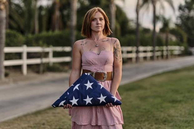 Katelyn Kleffman holds a folded flag outside her home in Perris, California. She says her husband, Staff Sgt. Courtland Bates Wind, had a history of depression and lived in fear of being kicked out of the Marine Corps. (Philip Cheung for The Washington Post) Katelyn Kleffman holds a folded flag outside her home in Perris, California