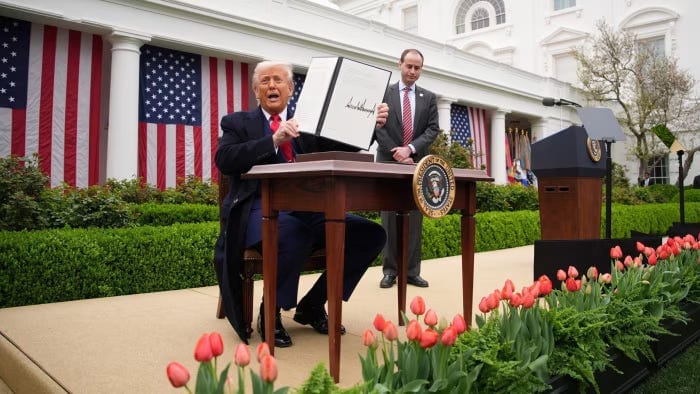 US President Donald Trump displays a signed executive order from a desk in the Rose Garden US President Donald Trump displays a signed executive order from a desk in the Rose Garden
