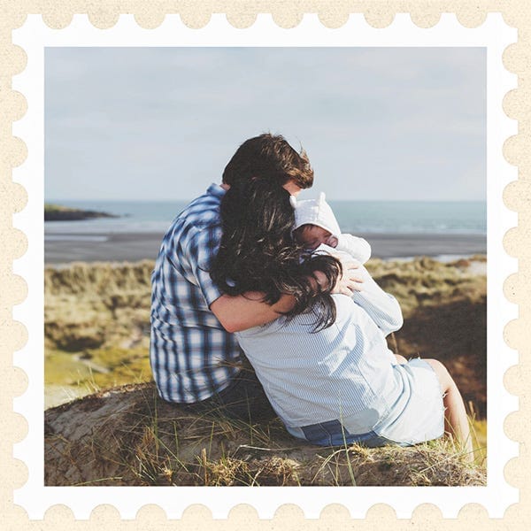 Image of an Irish family with a baby in embrace, sitting on the sand overlooking the ocean Image of an Irish family with a baby in embrace, sitting on the sand overlooking the ocean