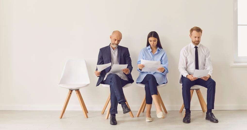 candidates sitting on chairs waiting for job interview