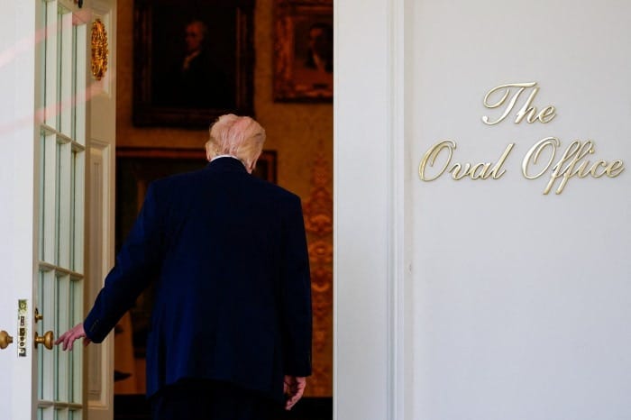 President Trump walking towards the Oval Office door.