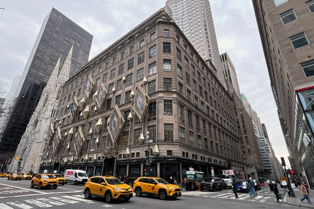 Saks Fifth Avenue Midtown building decorated with hanging diamond shapes, with a Gothic cathedral and modern skyscraper in the background. Saks Fifth Avenue Midtown building decorated with hanging diamond shapes, with a Gothic cathedral and modern skyscraper in the background.