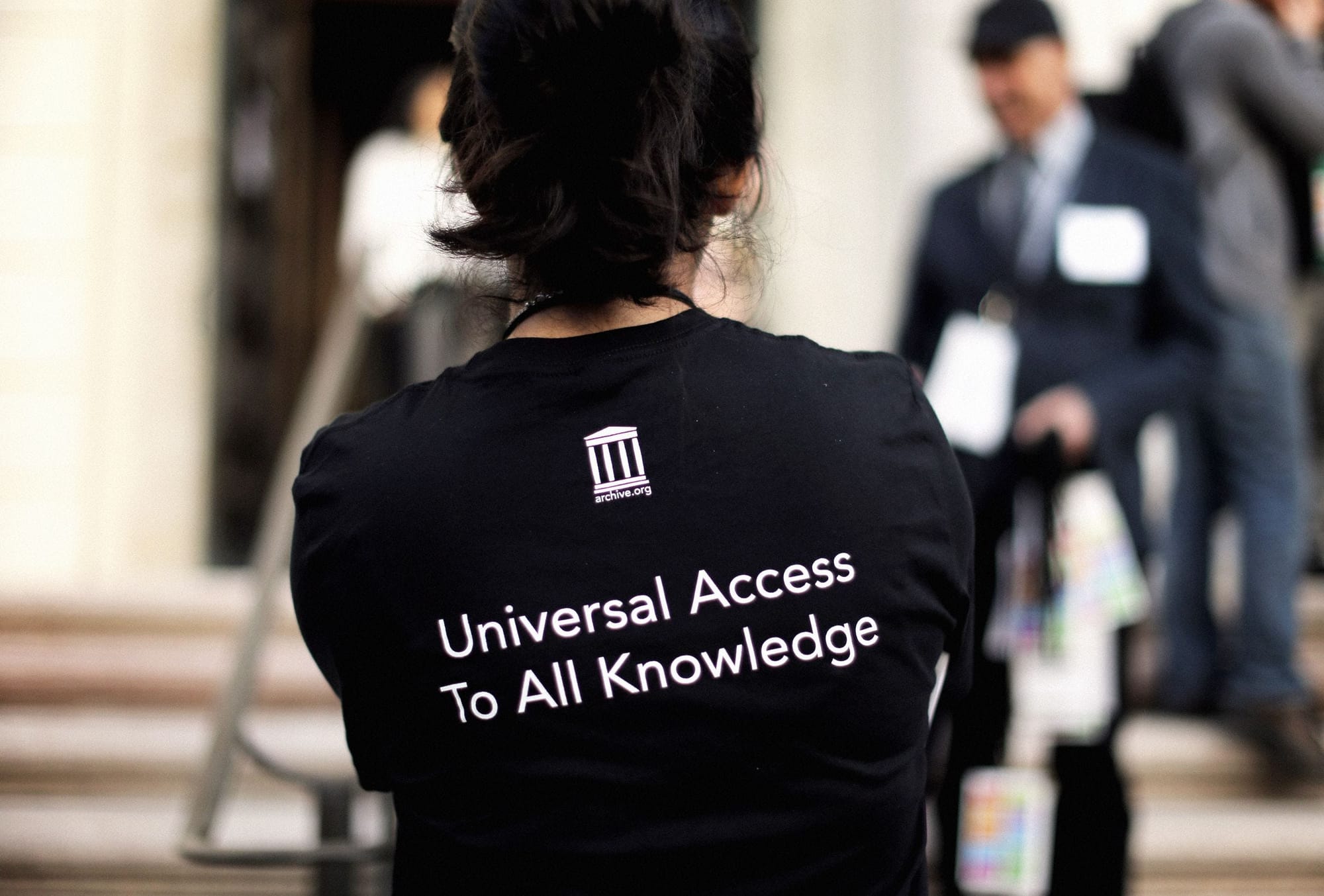A staff member wears a Universal Access to All Knowledge shirt during a 20th anniversary celebration of the Internet... A staff member wears a Universal Access to All Knowledge shirt during a 20th anniversary celebration of the Internet...