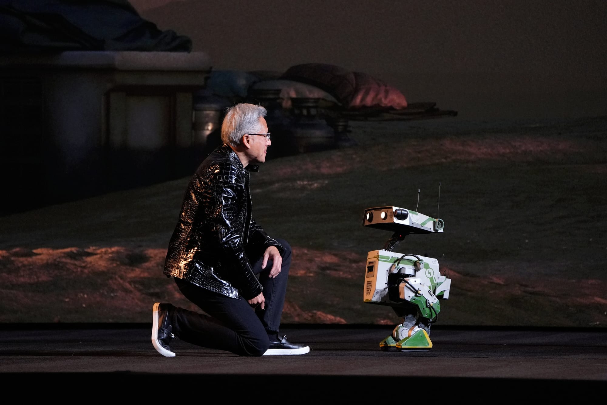 Nvidia founder and CEO Jensen Huang kneels in front of a robot during a Nvidia news conference ahead of the CES tech show Monday, Jan. 5, 2026 Nvidia founder and CEO Jensen Huang kneels in front of a robot during a Nvidia news conference ahead of the CES tech show Monday, Jan. 5, 2026