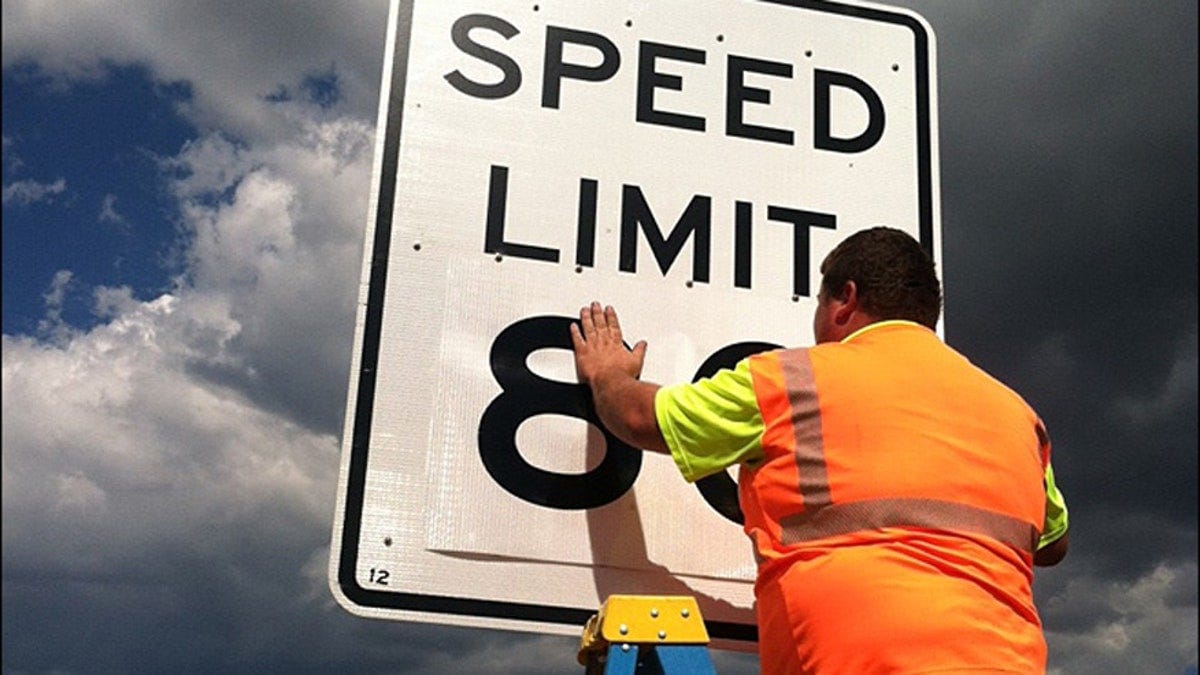 Man changing speed limit number Man changing speed limit number