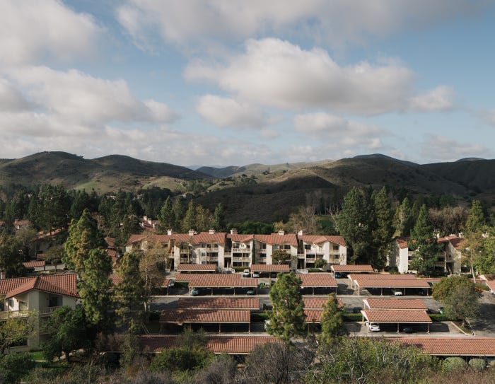 Aerial view of a condo complex nestled in a hilly landscape Aerial view of a condo complex nestled in a hilly landscape