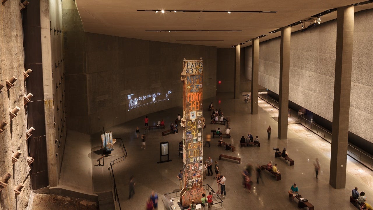 The Last Column in Foundation Hall is shown from above. Six museum visitors stand near the column, observing it up close. About forty visitors are walking through the expanse of Foundation Hall. The Last Column in Foundation Hall is shown from above. Six museum visitors stand near the column, observing it up close. About forty visitors are walking through the expanse of Foundation Hall.
