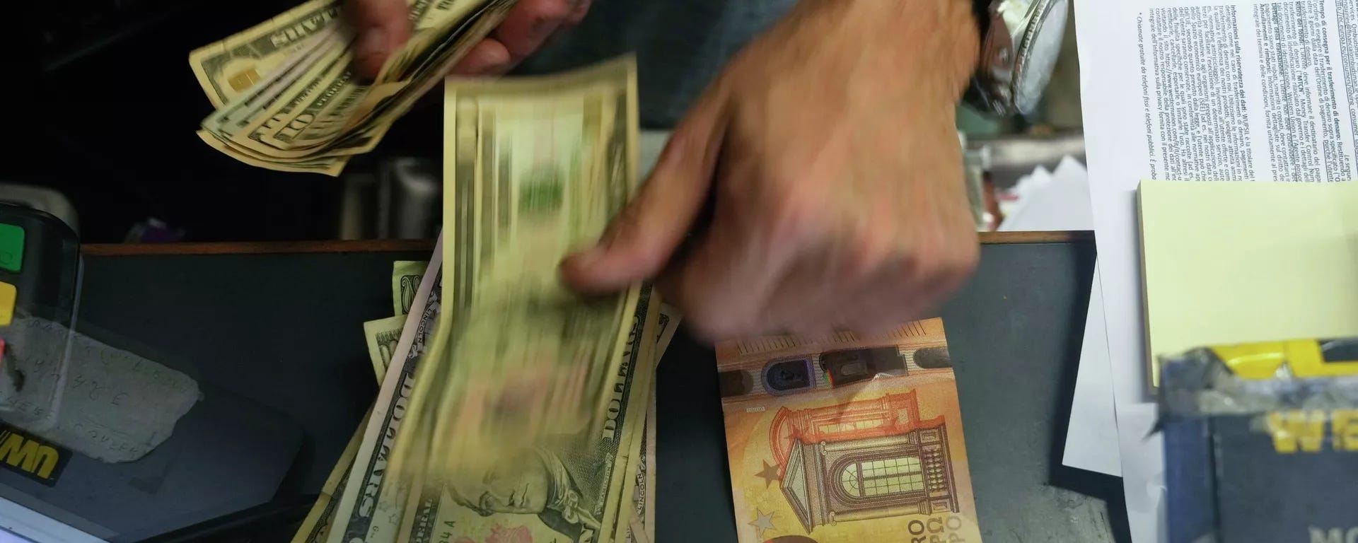 A cashier changes a 50 Euro banknote with US dollars. - Sputnik International, 1920, 28.07.2023 A cashier changes a 50 Euro banknote with US dollars. - Sputnik International, 1920, 28.07.2023