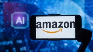 Amazon's logo on a cell phone against a background that says "AI" Amazon's logo on a cell phone against a background that says "AI"