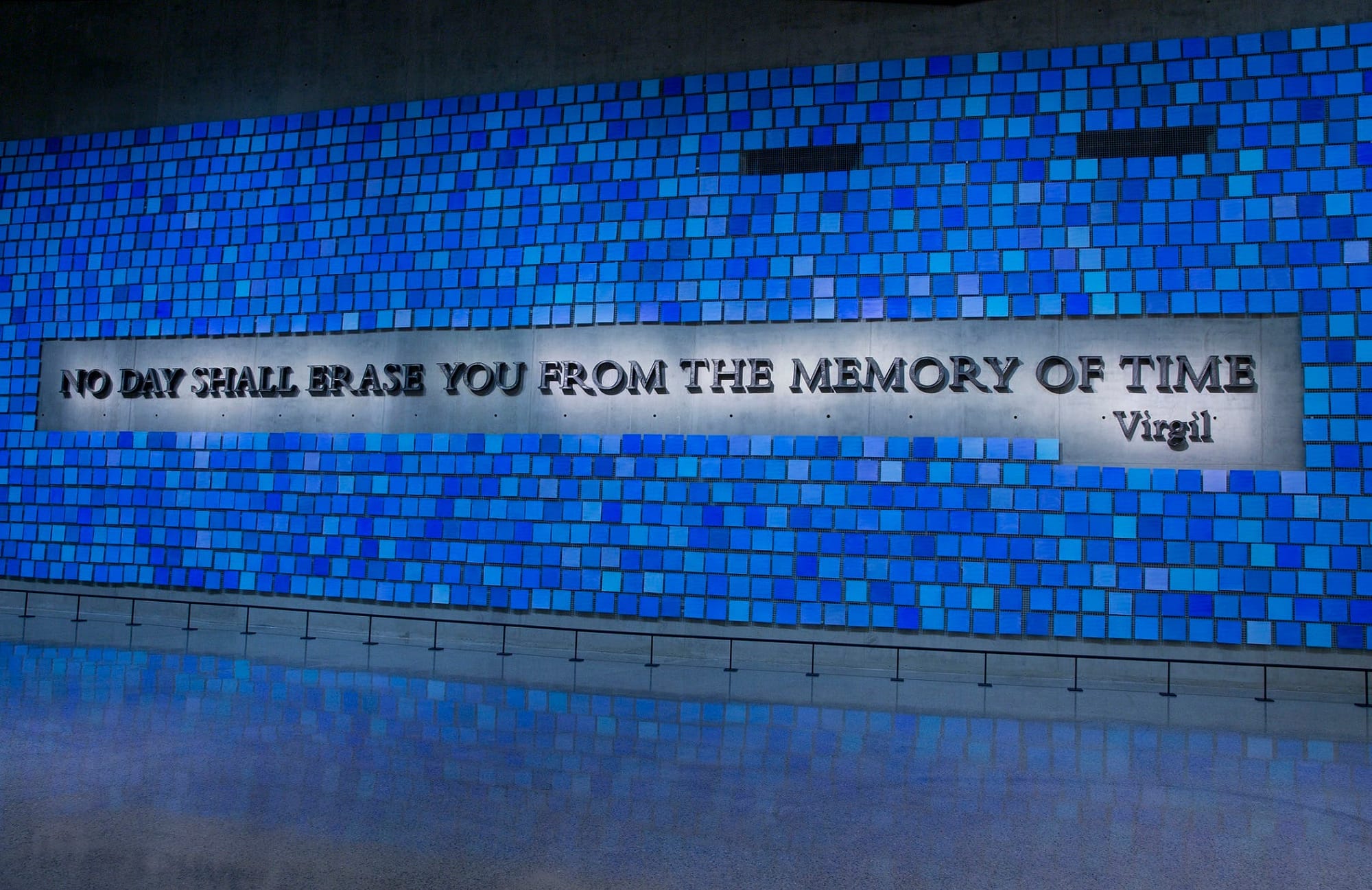 A large plaque in Memorial Hall reads, “No day shall erase you from the memory of time.” The quote from Virgil’s epic poem The Aeneid is surrounded by 2,983 individual blue tiles that comprise "Trying to Remember the Color of the Sky on That September Morning,” an installation by Spencer Finch. Every square is a unique shade of blue, reflecting the artist's attempt to remember the color of the sky on the morning of 9/11 and commemorating the victims of September 11, 2001 and February 26, 1993. A large plaque in Memorial Hall reads, “No day shall erase you from the memory of time.” The quote from Virgil’s epic poem The Aeneid is surrounded by 2,983 individual blue tiles that comprise "Trying to Remember the Color of the Sky on That September Morning,” an installation by Spencer Finch. Every square is a unique shade of blue, reflecting the artist's attempt to remember the color of the sky on the morning of 9/11 and commemorating the victims of September 11, 2001 and February 26, 1993.