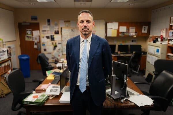 Joseph H. Thompson, a federal prosecutor, in a blue suit and light blue tie, stands near a desk. Joseph H. Thompson, a federal prosecutor, in a blue suit and light blue tie, stands near a desk.