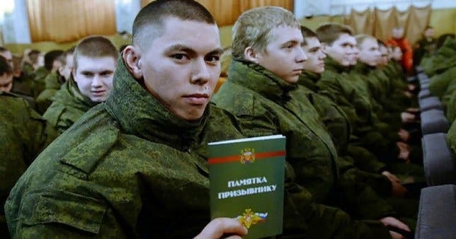 A Russian soldier sits with other new conscripts A Russian soldier sits with other new conscripts