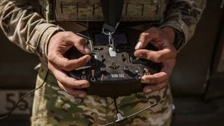 A soldier holding a drone A soldier holding a drone