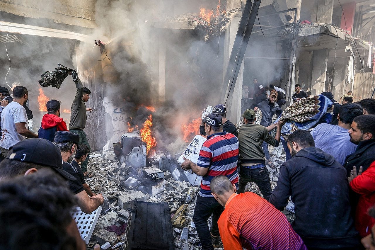 Palestinians transport the wounded and try to put out a fire after an Israeli airstrike on a house in the Shaboura refugee camp in the city of Rafah, southern Gaza Strip, November 17, 2023. (Abed Rahim Khatib/Flash90) Palestinians transport the wounded and try to put out a fire after an Israeli airstrike on a house in the Shaboura refugee camp in the city of Rafah, southern Gaza Strip, November 17, 2023. (Abed Rahim Khatib/Flash90)