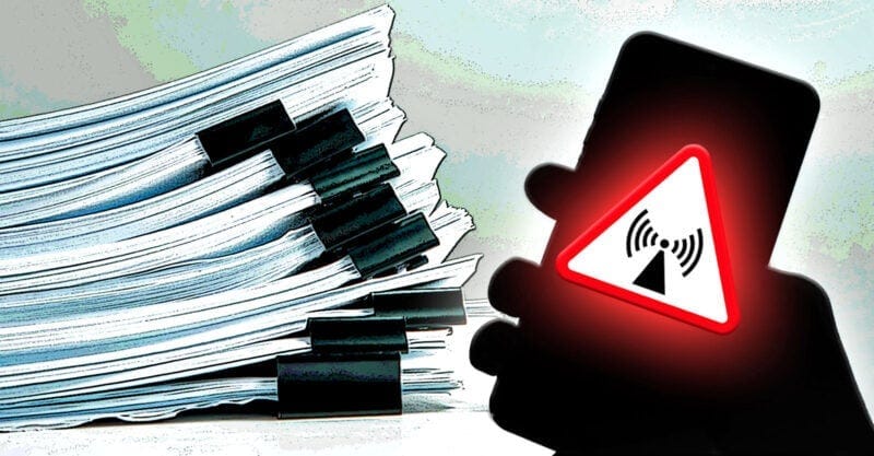stack of documents with hand holding cellphone with radiation symbol on top stack of documents with hand holding cellphone with radiation symbol on top