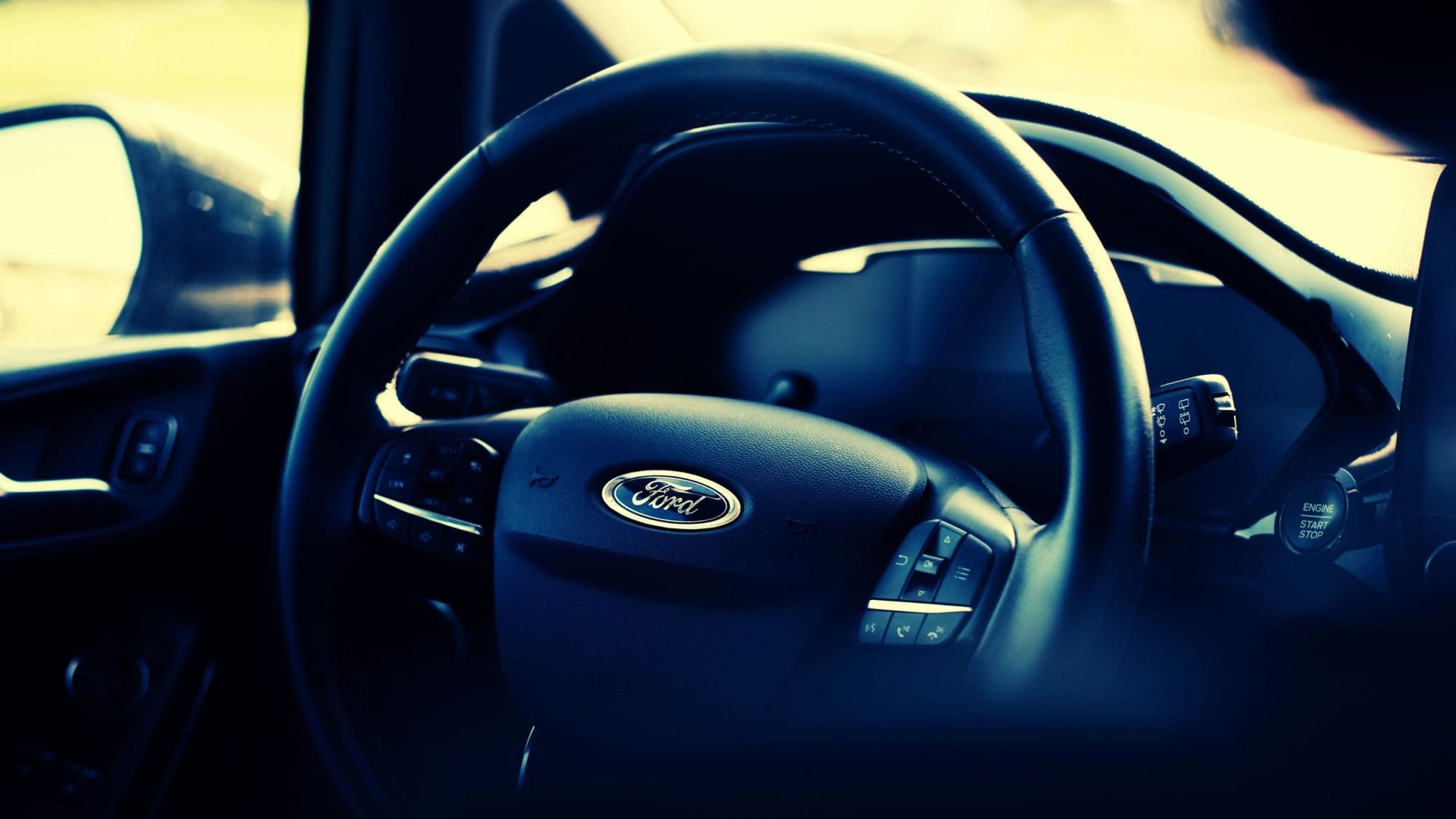 Close-up of a Ford vehicle's steering wheel with the logo prominently displayed. Close-up of a Ford vehicle's steering wheel with the logo prominently displayed.