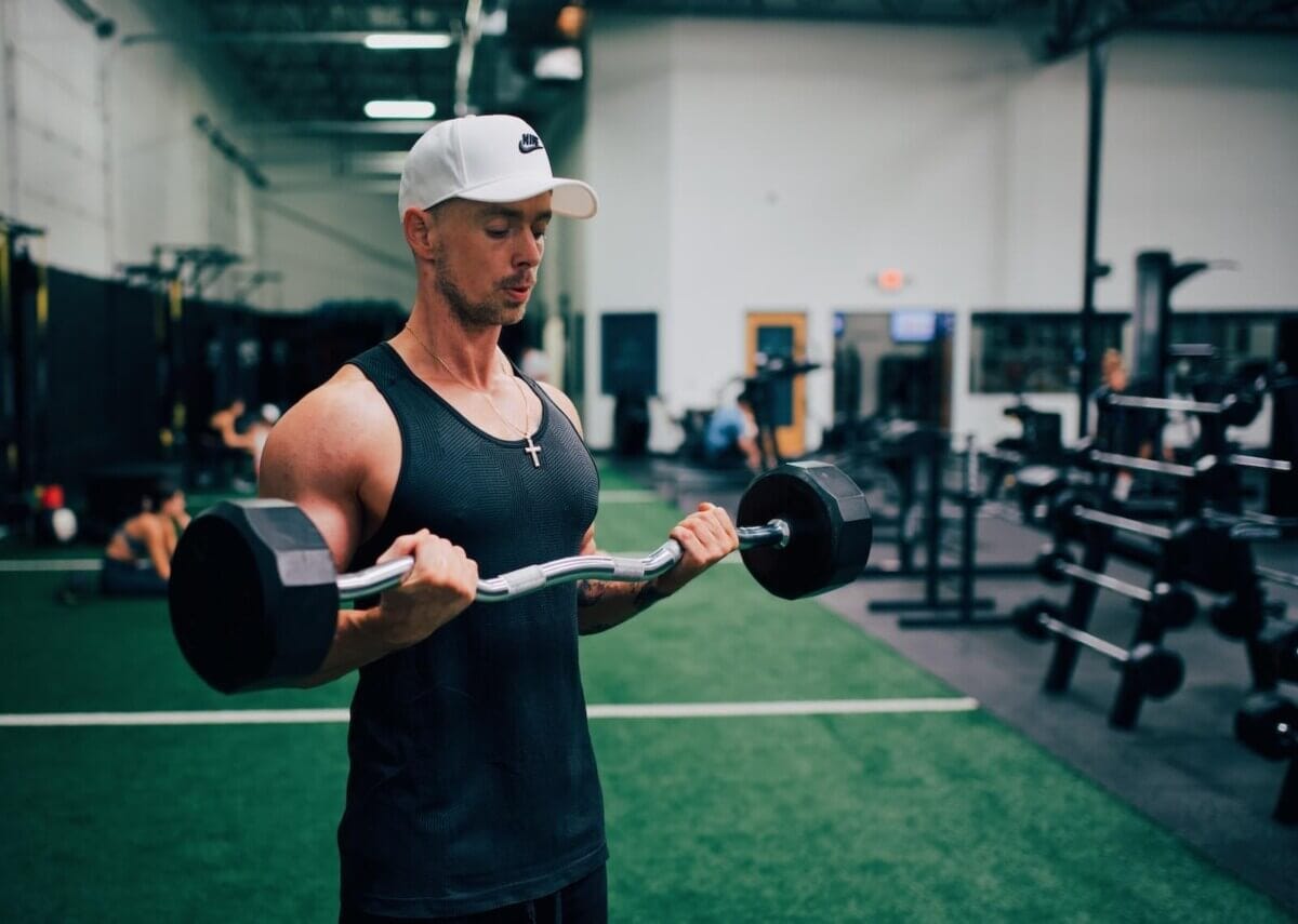 Man doing bicep curls while weightlifting in a gym. Man doing bicep curls while weightlifting in a gym.