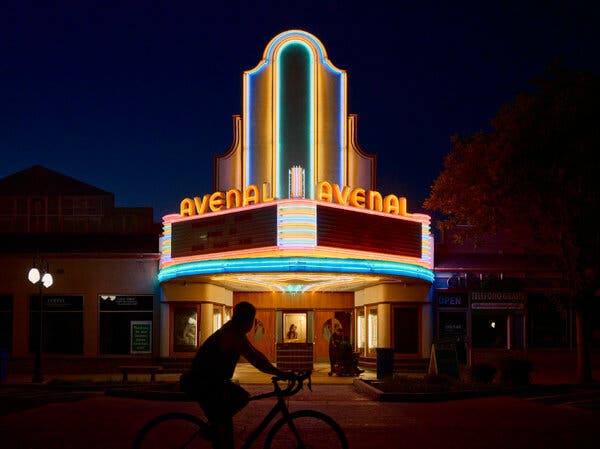 A theater with neon signage reading, “Avenal.”