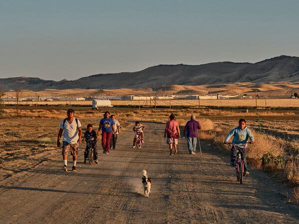 People walking and biking on an unpaved road.