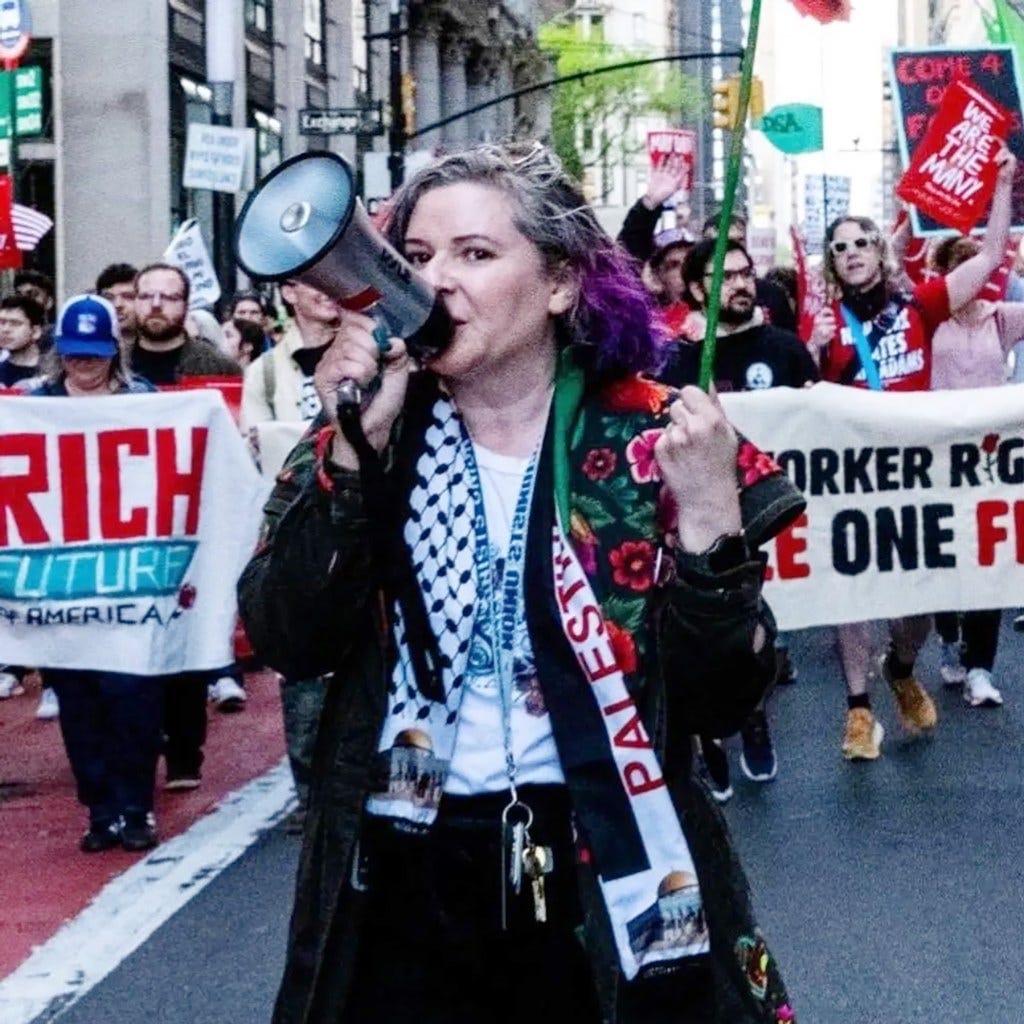 DSA labor coordinator Olivia Killingsworth with purple-dyed hair uses a megaphone to lead a protest.